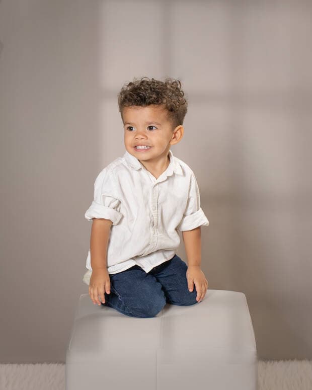 Niño sentado sobre cubo blanco