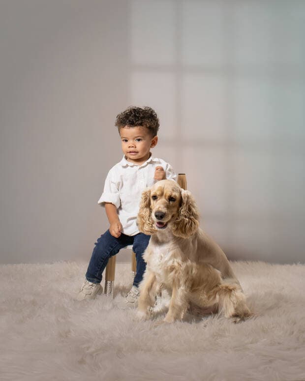 Niño con su perro sobre fondo claro