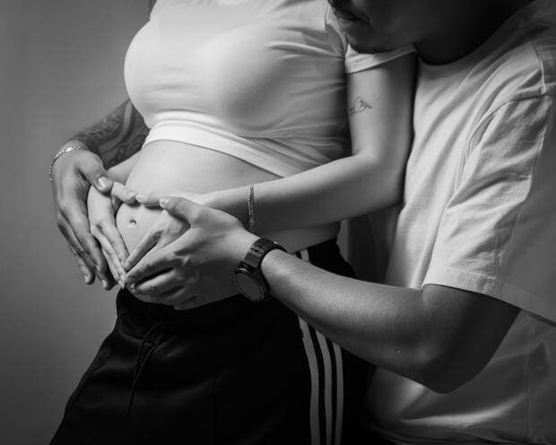 Manos sobre el vientre, blanco y negro