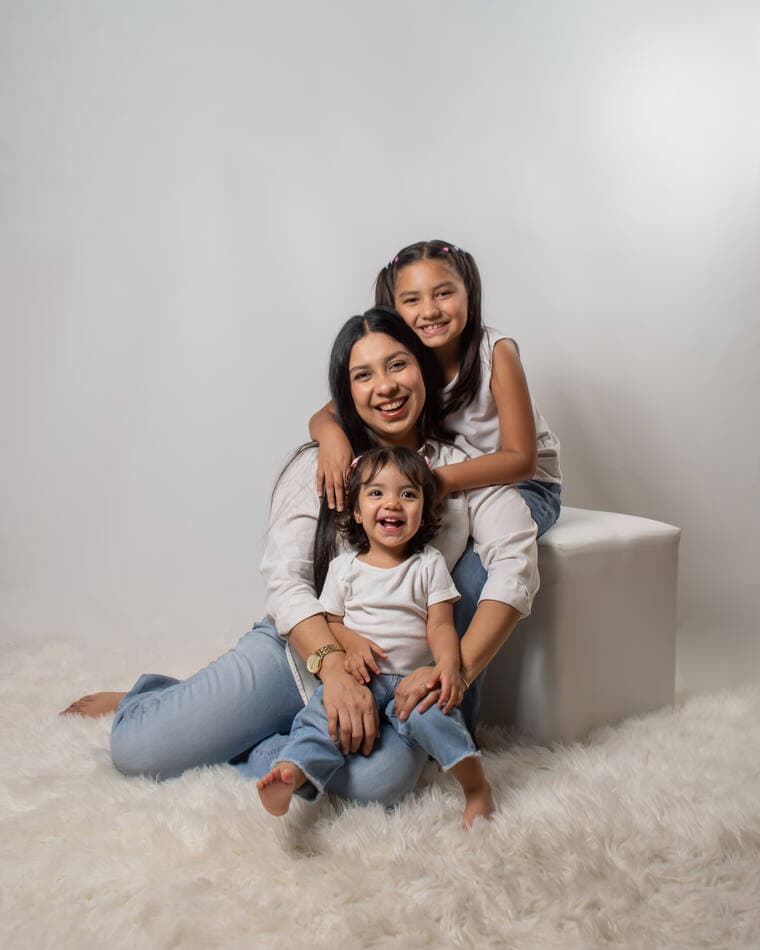 Madre con sus dos hijas sobre fondo blanco