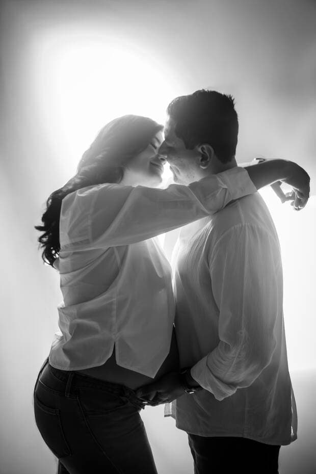 Pareja embarazada, beso a contraluz