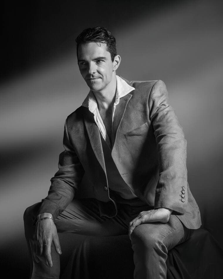 Retrato masculino sentado, luz dura sobre fondo negro